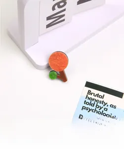 Detail of creative orange and green acrylic tree brooch with geometric resin textures