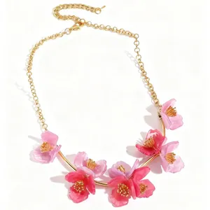 Collier élégant en chaîne dorée avec sept fleurs en résine rose vif et cœurs dorés