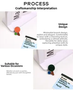 Close-up of minimalist tree-shaped acrylic brooches in orange and dark green textures