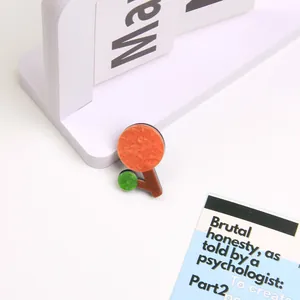 Minimalist handmade acrylic flower brooch with abstract geometric tree design on white desk