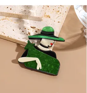 Détail d'une broche en acrylique avec texture marbre nacré vert sur socle en pierre