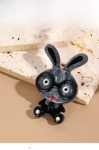 Macro shot of stylish acrylic rabbit brooch with marble texture and rhinestone accents