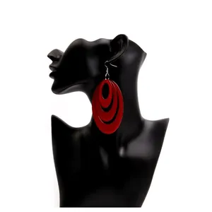 Minimalist red acrylic layered oval hoop earrings on a black silhouette display stand