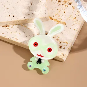 Cartoon acrylic rabbit brooch with green glasses and faux gem accents on stone base