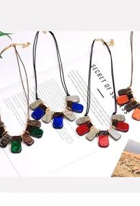 Détail de pendentifs rectangulaires en résine marbrée colorée sur des colliers tressés