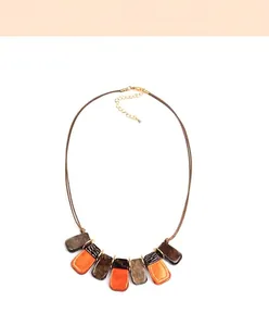 Détail du collier de luxe en résine acrylique géométrique avec liens dorés et cordon