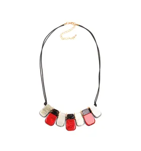 Détail du collier bohème en résine avec segments colorés et entretoises en métal doré