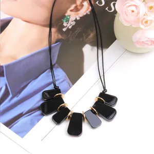 Collier élégant avec pendentif rectangulaire en acrylique noir et anneaux dorés
