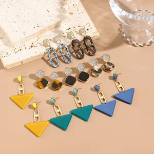 Vue détaillée de boucles d'oreilles géométriques en acrylique bleu marbre et noir chic