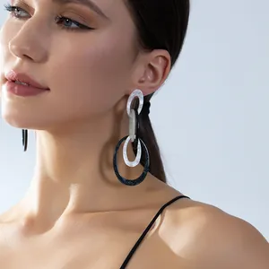 Boucles d'oreilles géométriques en acrylique avec motif marbré portées par mannequin