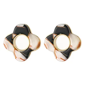 Elegant four-petal floral earrings with black and amber marble resin and gold accents