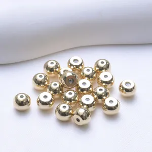 Macro view of polished 18K gold-plated 5mm round ball beads for DIY jewelry making