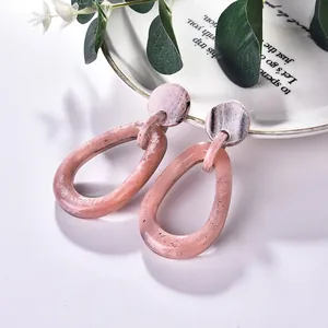Pink marbled resin and acrylic geometric teardrop earrings in a modern retro style