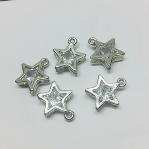 Detailed view of five silver star charms with clear zircon inlays on white background