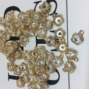 Macro detail of gold flower alloy pendants with sparkling zircon for DIY jewelry making
