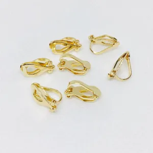 Seven pieces of gold-plated copper triangle clip-on earring converters on white surface