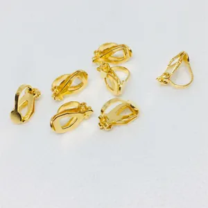 Detailed macro view of seven polished gold triangular clip-on earring converters for DIY jewelry