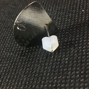 Macro shot of silver metal shield-shaped earring back with heart silicone plug