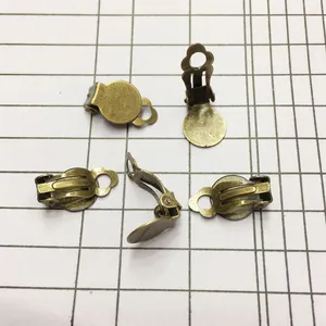 Vista macro detallada de cuatro clips de pendientes en bronce antiguo para joyería DIY