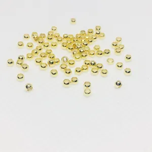 Macro shot of 14k gold-filled crimp beads for DIY jewelry making on white background