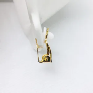 Detalle del convertidor de pendientes de clip dorado con almohadilla de silicona blanca