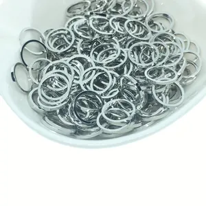 Bulk silver circular metal jump rings for DIY jewelry in a white ceramic bowl
