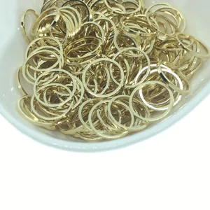 14k gold plated minimalist circular DIY jewelry charms and rings in a white ceramic bowl