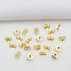 Primer plano de cierres de mariposa y topes de disco bañados en oro 14k para joyas DIY