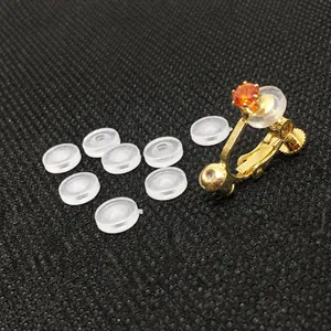 Detalle de clips de oreja en U dorados con circón y almohadillas de silicona confort