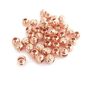 Macro detail of 14K gold plated rose gold spacer beads with spiral textured finish