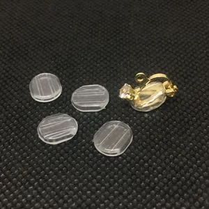 Detalle de almohadillas de silicona y convertidor de pendientes dorado con circonita clara
