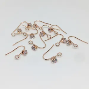 Détails macro des crochets d'oreilles en or rose sertis de zircons ronds étincelants