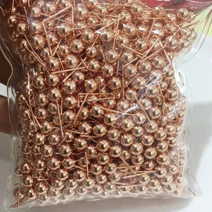 Macro shot of bulk rose gold plated ball head pins in a transparent packaging bag