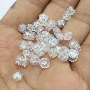 Macro shot of clear silicone earring backs with silver metal core held in palm