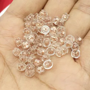 Macro view of clear silicone ear nuts with rose gold core held in hand for jewelry DIY