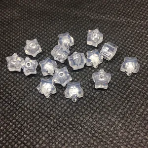 Macro shot of transparent star-shaped acrylic spacer beads with holes for DIY jewelry
