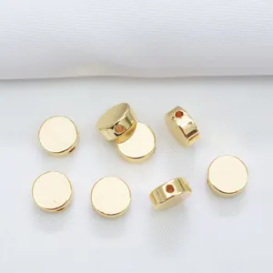 Detalle macro de cuentas espaciadoras planas de oro de 14k con acabado pulido para DIY
