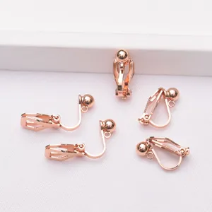 Primer plano de cinco convertidores de pendientes de clip triangulares en oro rosa