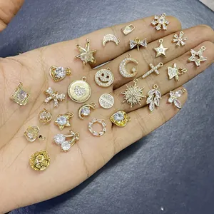 Ciondoli placcati oro 14k con zirconi micro-pave a forma di stelle e fiocchi su mano