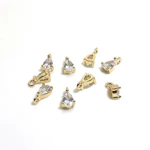 Detailed view of eight gold plated pear shaped zircon pendants for DIY jewelry making