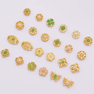 Detailed close-up of gold-plated clover, flower, and butterfly beads with green agate