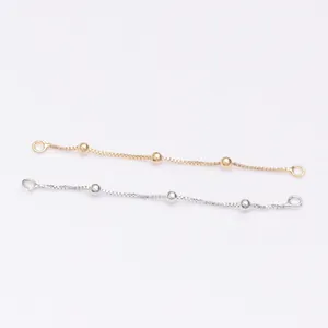 Detailed macro view of 14k gold and silver box chains with polished beads for DIY jewelry