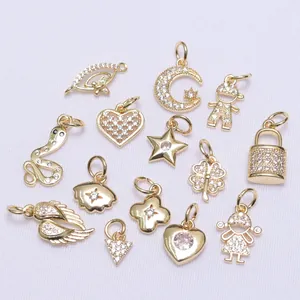 Macro shot of 14k gold plated charms with zircon inlay in heart, star, and clover shapes