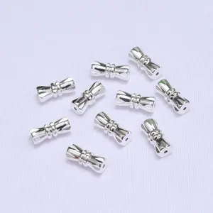 Set of 10 silver metal hourglass shaped DIY jewelry spacers with textured detail