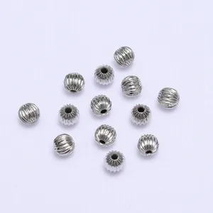 Macro detail of silver melon-shaped beads with vertical grooves for DIY jewelry making