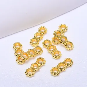 Vue macro de perles d'espacement à triple anneau plaqué or 18 carats avec texture torsadée