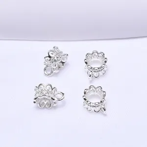 Macro view of four silver hollow flower petal spacers for DIY jewelry making and beading