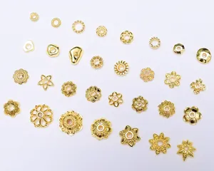 Dettaglio di vari distanziatori floreali placcati in oro 18K per gioielli fai-da-te