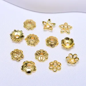 Vista dettagliata di undici copriperla e distanziatori floreali placcati oro 18K per gioielli