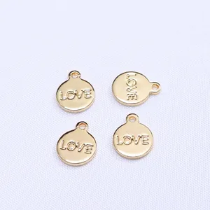 Close-up of four 14k gold-filled round pendants with LOVE engraving for DIY jewelry
